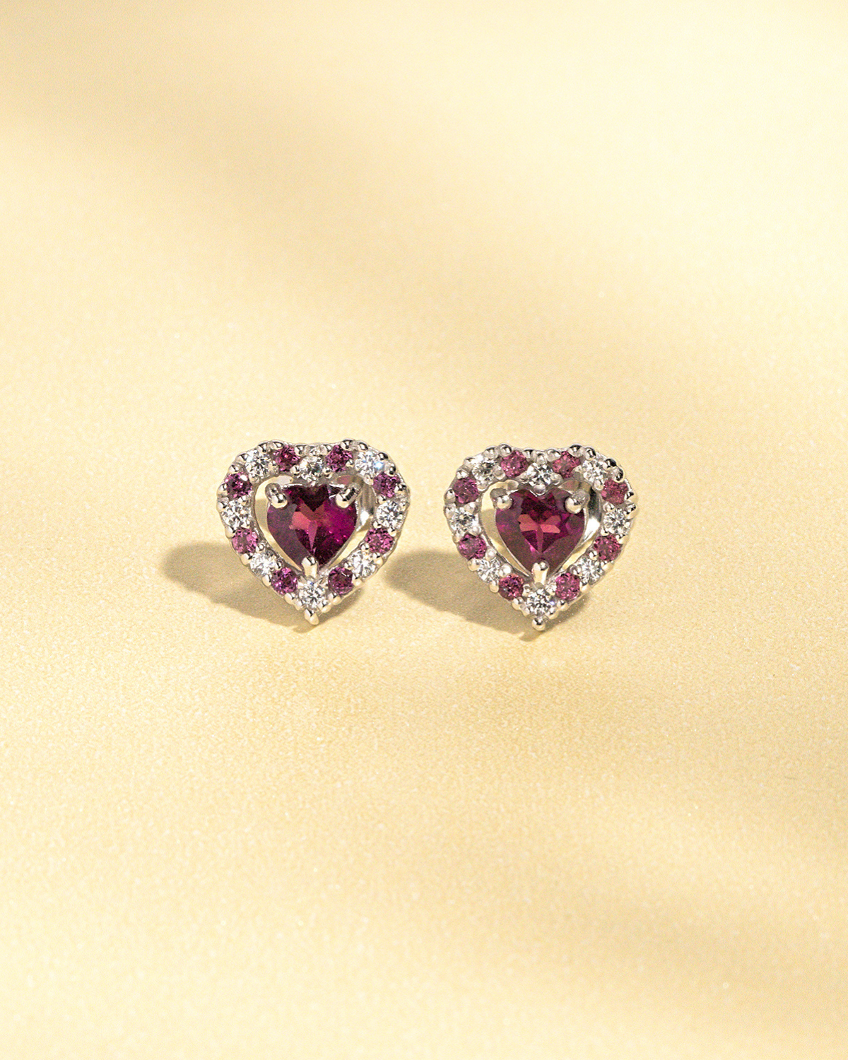 Boucles d'oreilles puces en argent sterling, serties de grenat rhodolite en forme de cœur rouge.